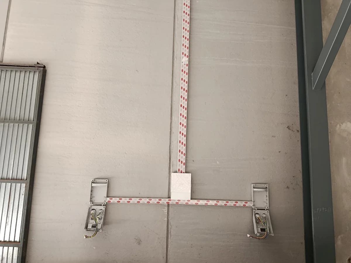 Canalización superficial y cajas eléctricas instaladas en una pared industrial