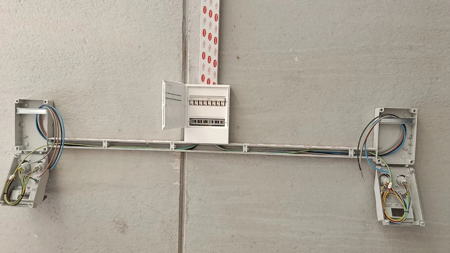 Canalización y cuadros eléctricos instalados sobre una pared de una nave industrial en Valls